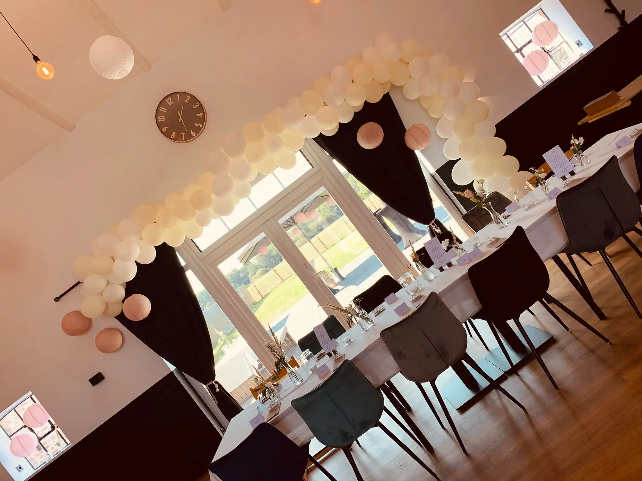Ballonbogen in Creme und Rosé über der Festtafel im Saal