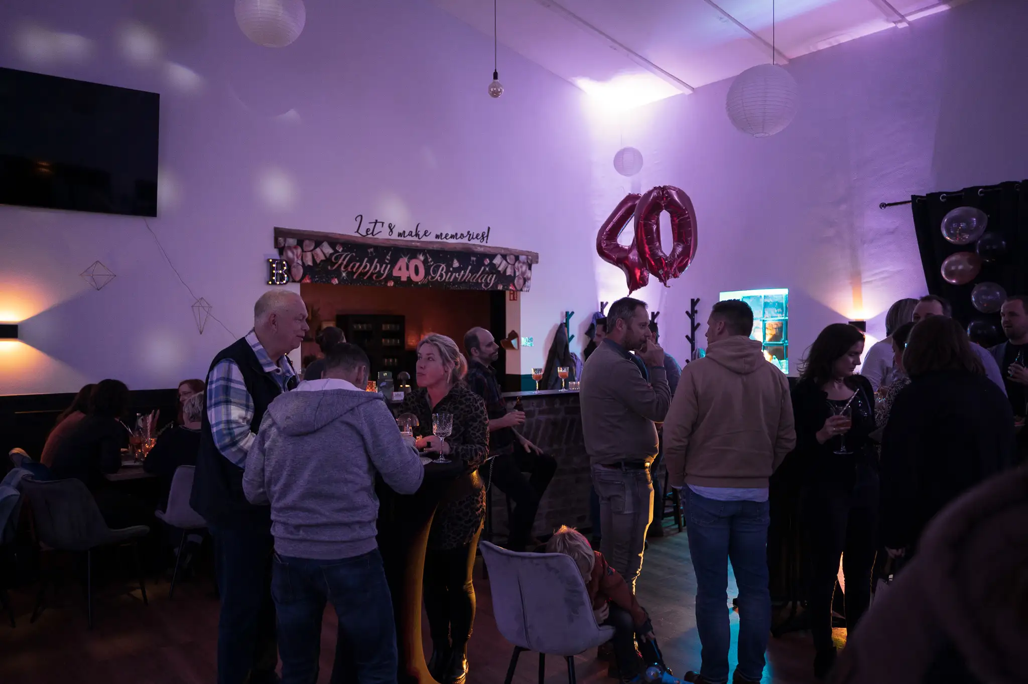 Gäste feiern einen runden Geburtstag im stimmungsvoll beleuchteten Saal