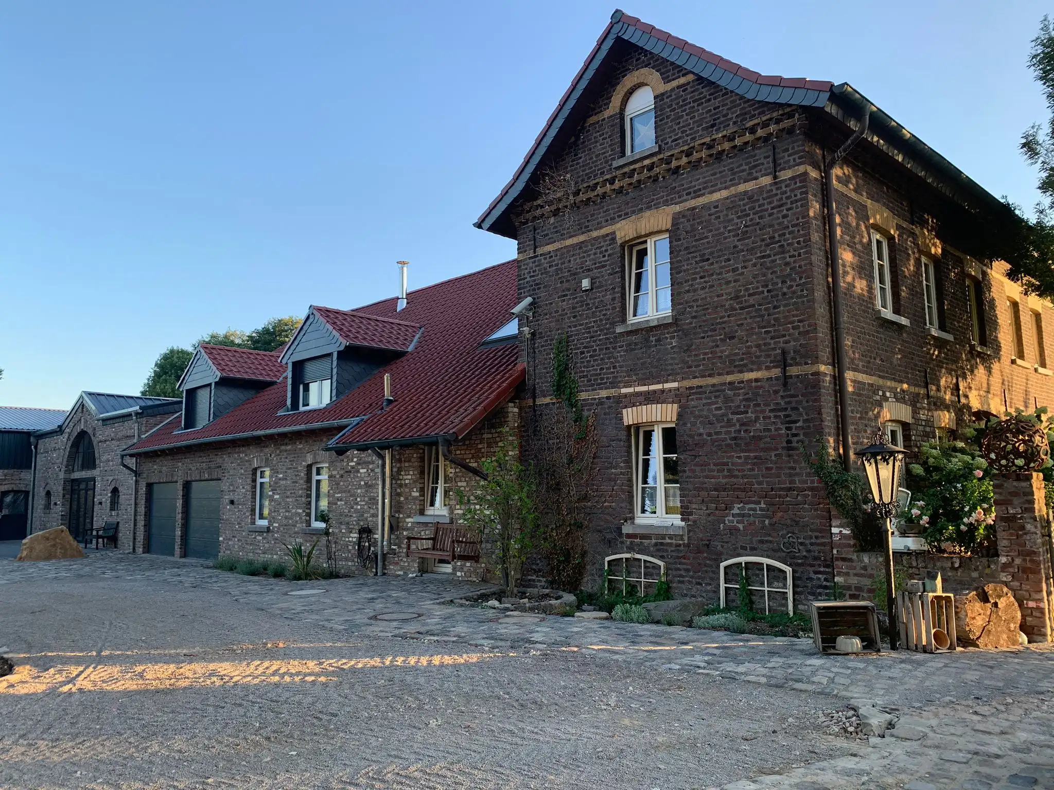 Das Backsteinhaupthaus des Borghofs mit dem gepflasterten Innenhof im Abendlicht