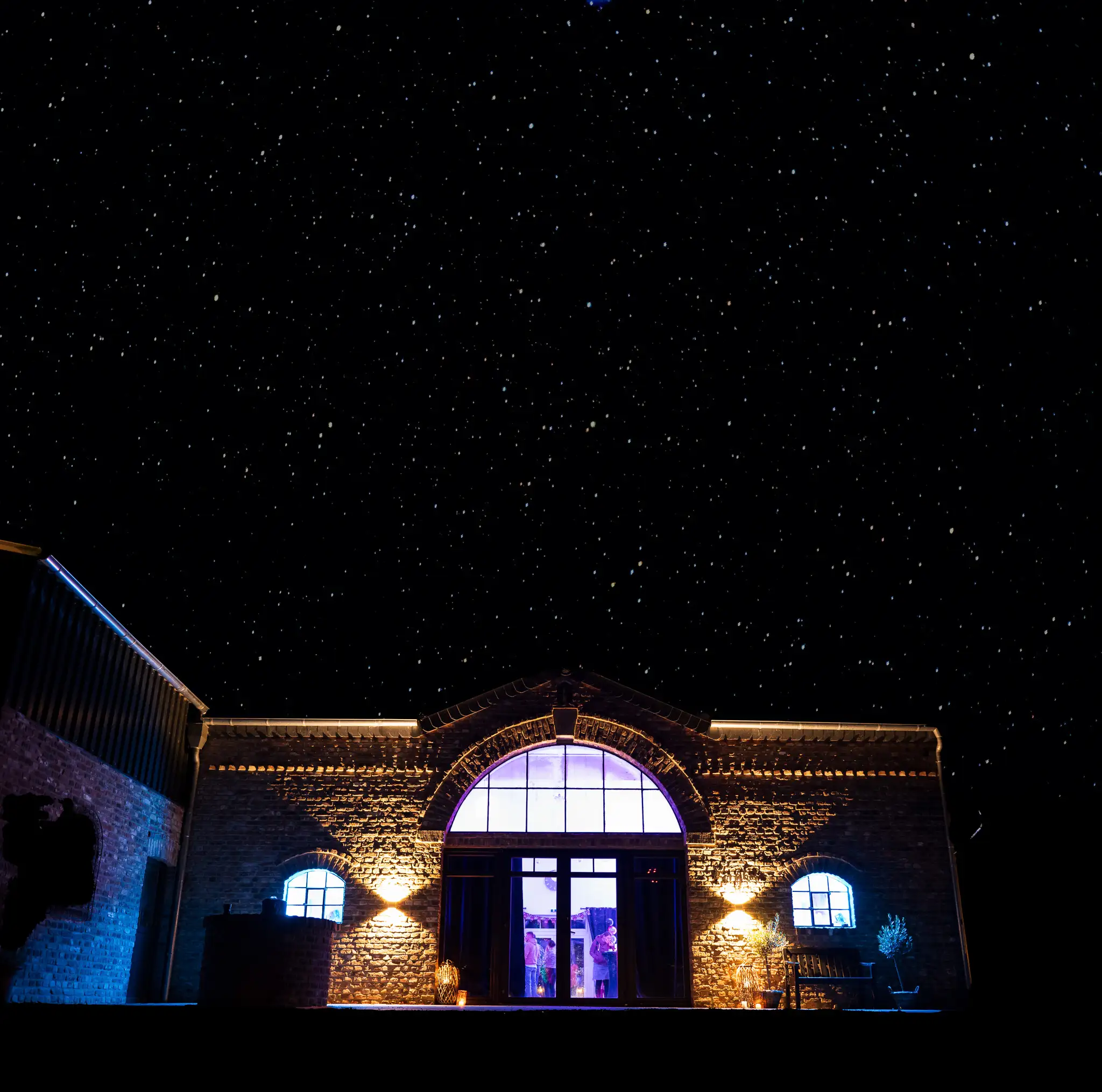 Der beleuchtete Borghof bei Nacht unter einem klaren Sternenhimmel