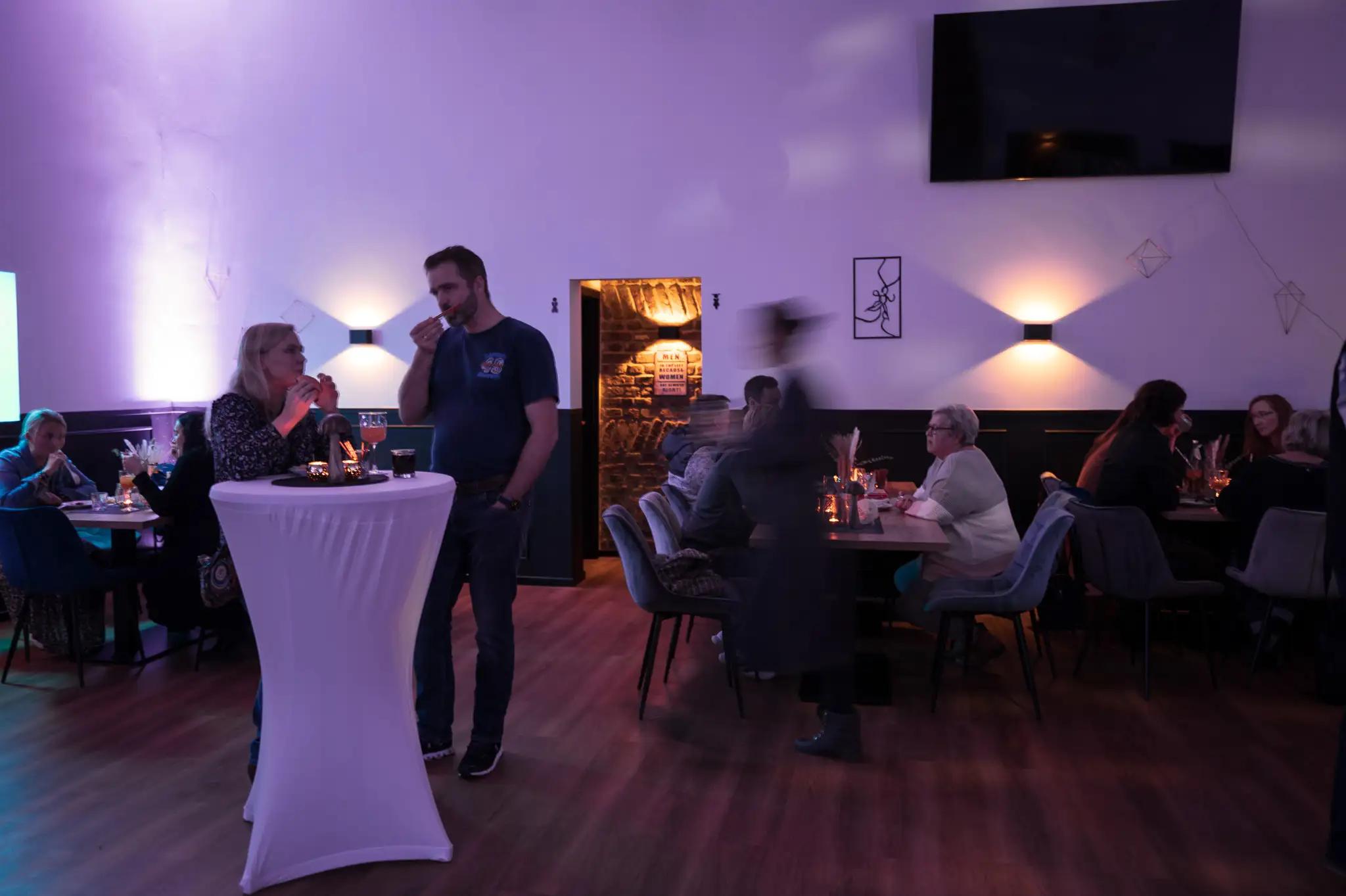Gäste im Gespräch an Stehtischen im Saal