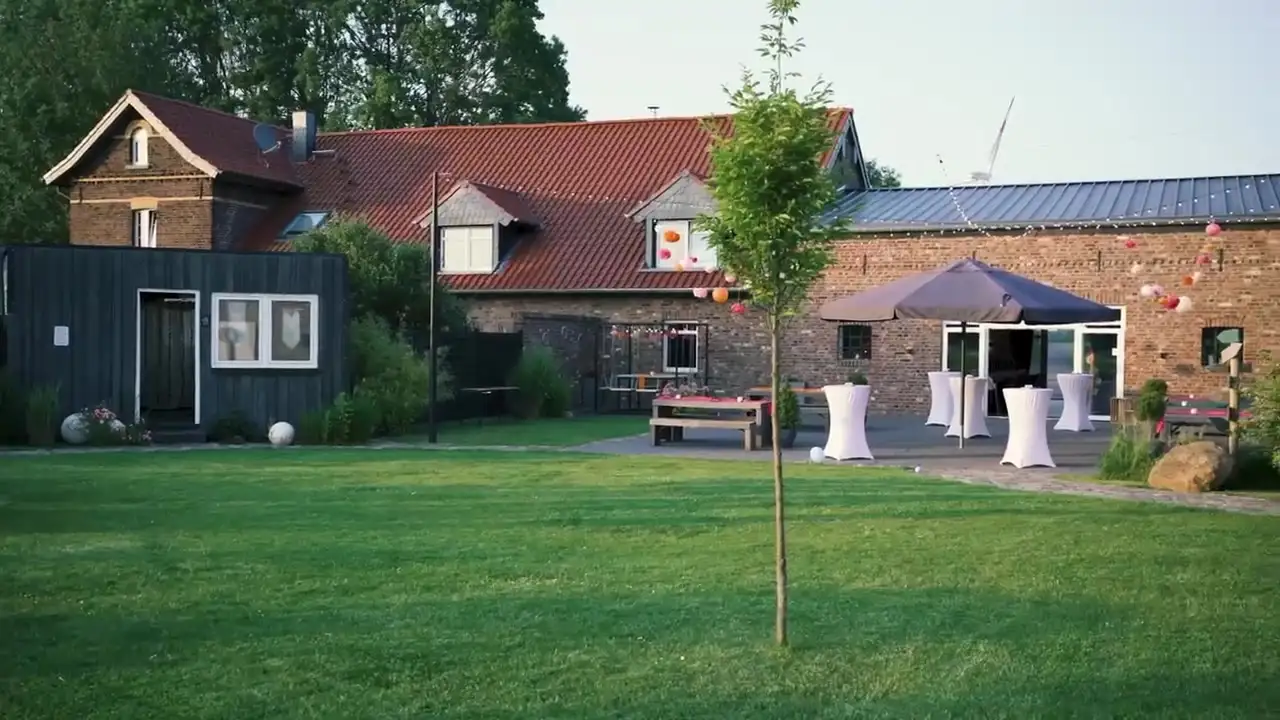 Stehtische mit weißen Hussen auf der Rasenfläche vor den Hofgebäuden