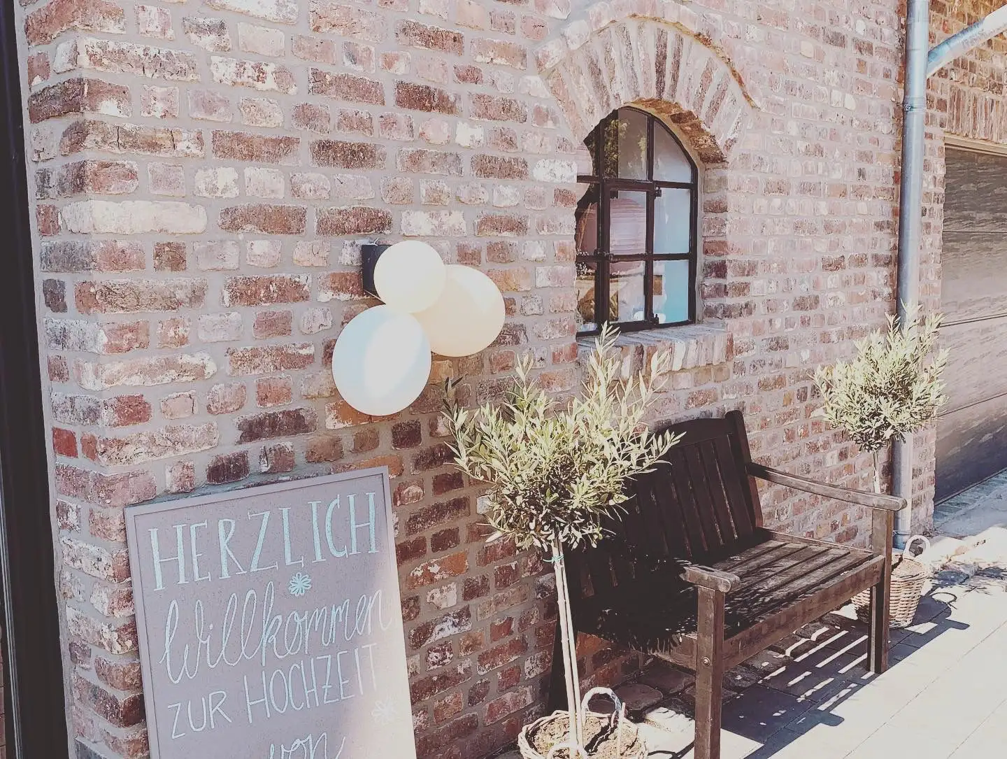 Handgeschriebenes Willkommensschild zur Hochzeit an der Backsteinwand